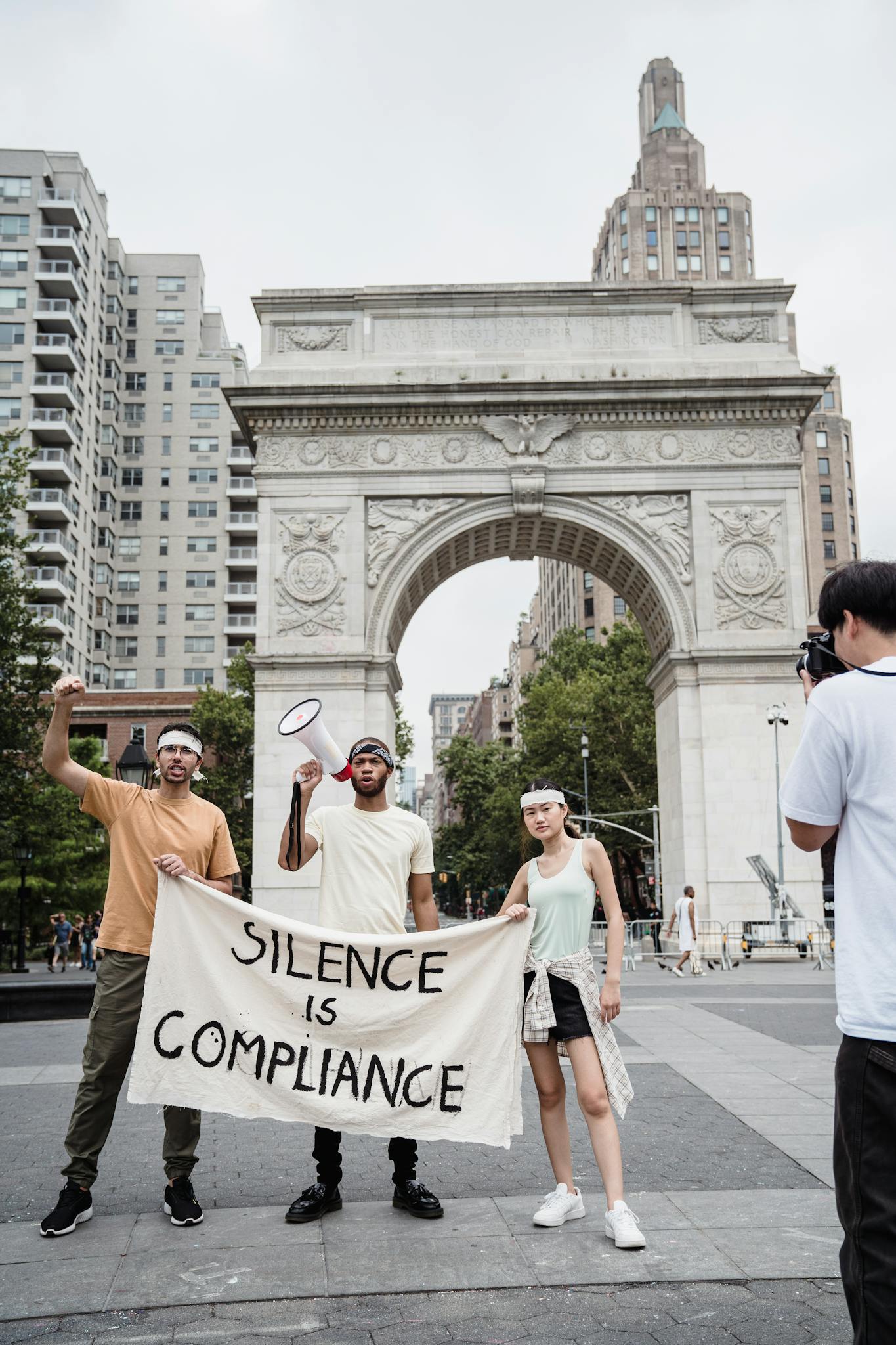 Protesters with a 'Silence is Compliance' banner at Washington Square Arch rally.