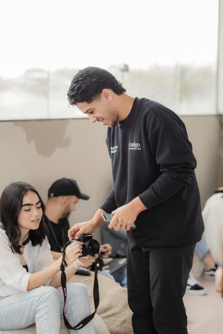 Young adults learning photography in an interactive hands-on workshop indoors.